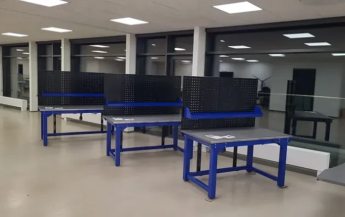 Robuste Werkbänke mit Lochplatten zur Aufbewahrung von Werkzeugen und Zubehör in einem modernen Arbeitsbereich.